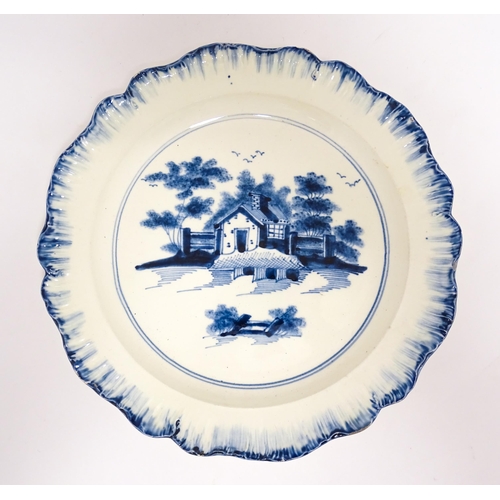 63 - An English blue and white plate with feather edge with hand painted decoration depicting a cottage i... 