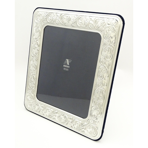 650 - An Italian photograph frame with easel back and white metal surround with acanthus scroll decoration... 