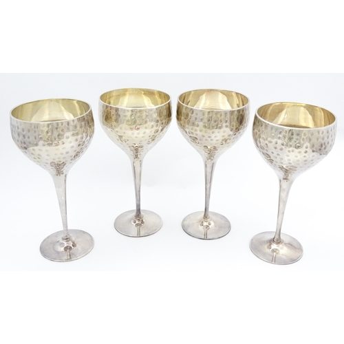 717 - Four late 20th / early 21stC silver plate goblets with hammered decoration. Approx. 8