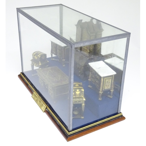 1497 - A showcase containing a display of early 21stC scale model miniature models of furniture to include ... 