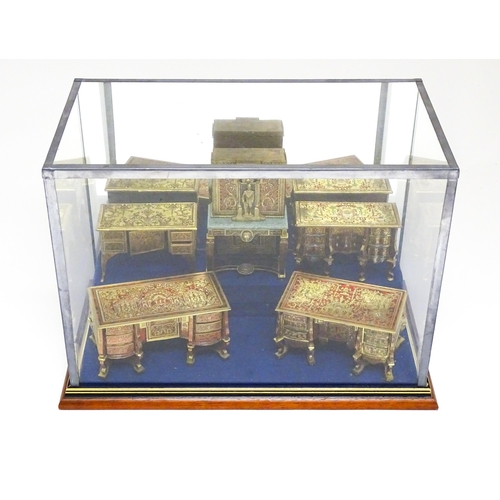 1498 - A showcase containing a display of early 21stC scale model miniature models of furniture to include ... 