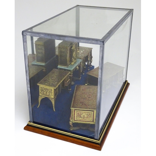 1498 - A showcase containing a display of early 21stC scale model miniature models of furniture to include ... 