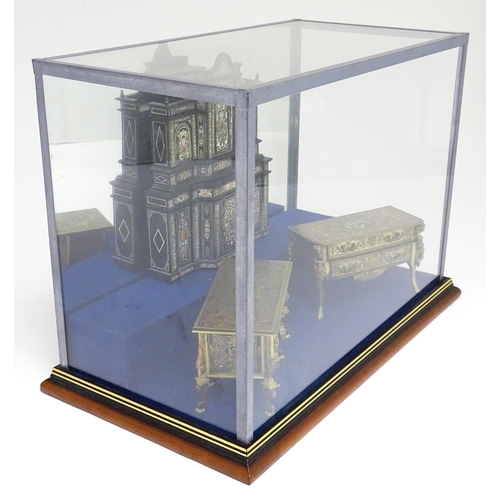 1500 - A showcase containing a display of early 21stC scale model miniature models of furniture to include ... 