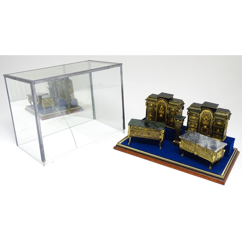 1501 - A showcase containing a display of early 21stC scale model miniature models of furniture to include ... 