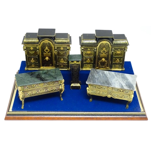 1501 - A showcase containing a display of early 21stC scale model miniature models of furniture to include ... 