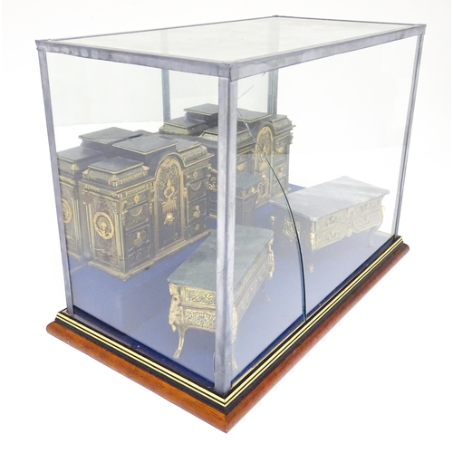 1501 - A showcase containing a display of early 21stC scale model miniature models of furniture to include ... 