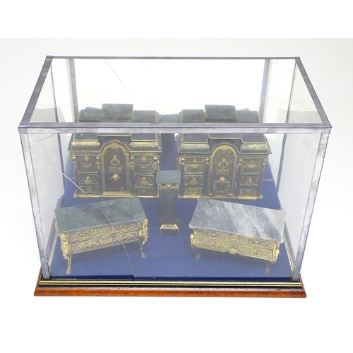 1501 - A showcase containing a display of early 21stC scale model miniature models of furniture to include ... 