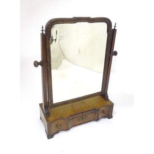 80 - A Georgian mahogany toilet mirror with an ogee moulded frame, straight uprights surmounted by finial... 