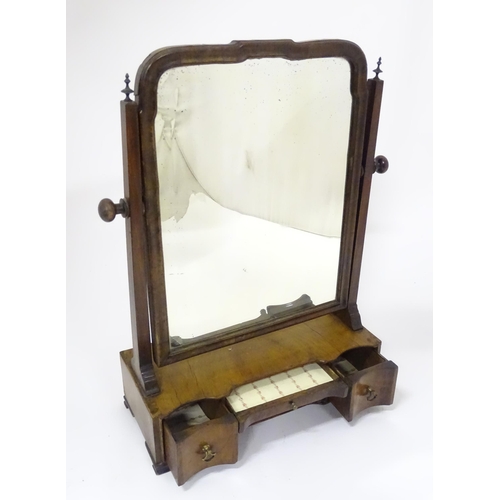 80 - A Georgian mahogany toilet mirror with an ogee moulded frame, straight uprights surmounted by finial... 