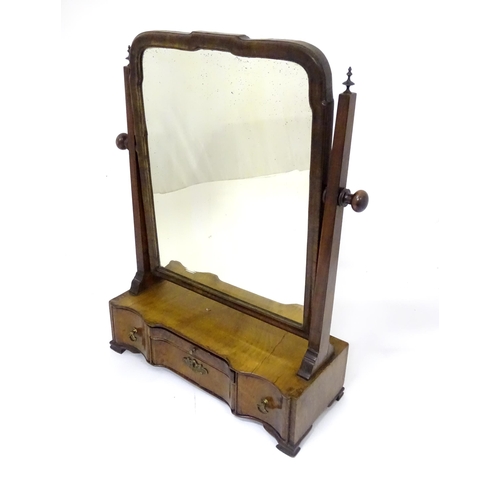 80 - A Georgian mahogany toilet mirror with an ogee moulded frame, straight uprights surmounted by finial... 