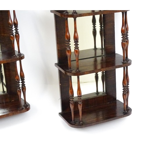 1744 - A pair of rosewood veneered mirrored wall shelves, each with four shelves supported by thin turned s... 