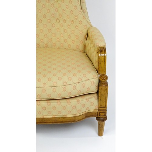 1831 - A pair of  20thC armchairs surmounted by brass finials, the chairs having deep buttoned cushions, in... 