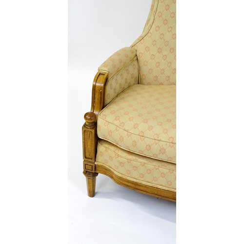 1831 - A pair of  20thC armchairs surmounted by brass finials, the chairs having deep buttoned cushions, in... 