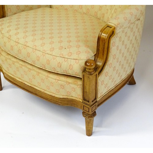 1831 - A pair of  20thC armchairs surmounted by brass finials, the chairs having deep buttoned cushions, in... 