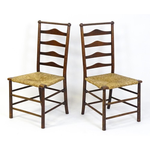 1833 - A pair of late 19thC Arts & Crafts ladderback chairs with graduated back rails above envelope rush s... 