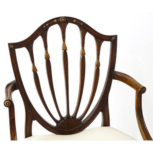 1862A - A George III mahogany Hepplewhite library chair with a shield shaped backrest and carved floral deta... 