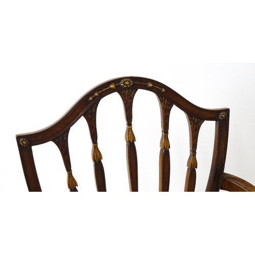 1862A - A George III mahogany Hepplewhite library chair with a shield shaped backrest and carved floral deta... 