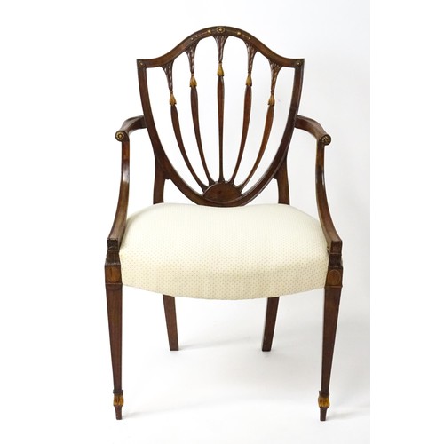 1862A - A George III mahogany Hepplewhite library chair with a shield shaped backrest and carved floral deta... 