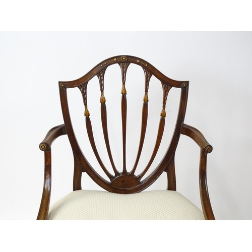 1862A - A George III mahogany Hepplewhite library chair with a shield shaped backrest and carved floral deta... 