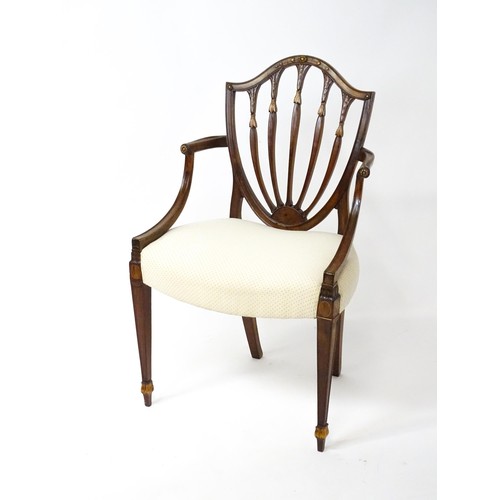 1862A - A George III mahogany Hepplewhite library chair with a shield shaped backrest and carved floral deta... 