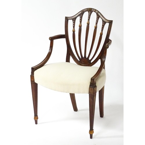 1862A - A George III mahogany Hepplewhite library chair with a shield shaped backrest and carved floral deta... 