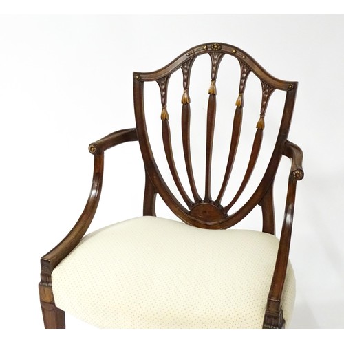 1862A - A George III mahogany Hepplewhite library chair with a shield shaped backrest and carved floral deta... 