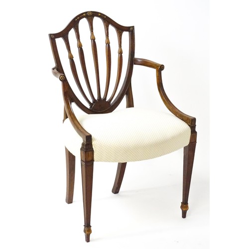 1862A - A George III mahogany Hepplewhite library chair with a shield shaped backrest and carved floral deta... 