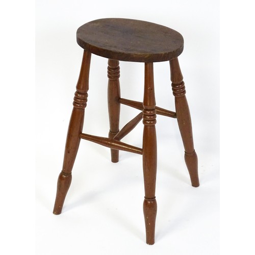 1753A - A 19thC high stool with an oval top raised on four turned tapering legs united by a H - stretcher. 1... 