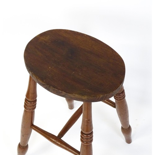 1753A - A 19thC high stool with an oval top raised on four turned tapering legs united by a H - stretcher. 1... 