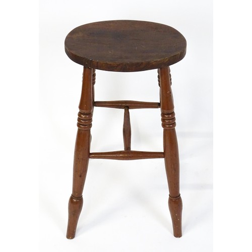 1753A - A 19thC high stool with an oval top raised on four turned tapering legs united by a H - stretcher. 1... 