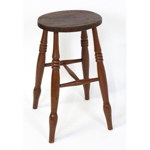 1753A - A 19thC high stool with an oval top raised on four turned tapering legs united by a H - stretcher. 1... 