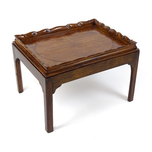 1745A - A Georgian Irish tray top table with a scrolled carved tray raised on a peg jointed base. 29