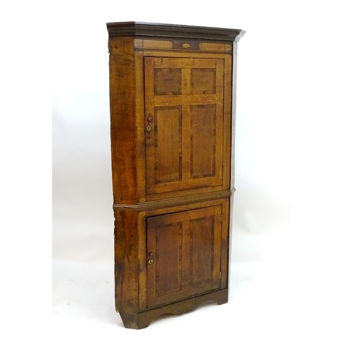 1718A - A mid / late 18thC oak double corner cupboard with a moulded cornice above a satinwood inlaid frieze... 