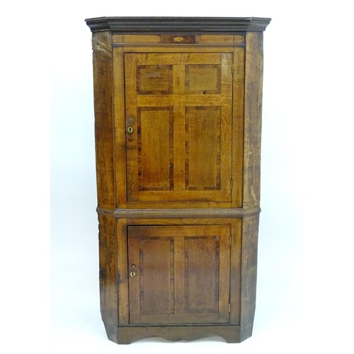 1718A - A mid / late 18thC oak double corner cupboard with a moulded cornice above a satinwood inlaid frieze... 