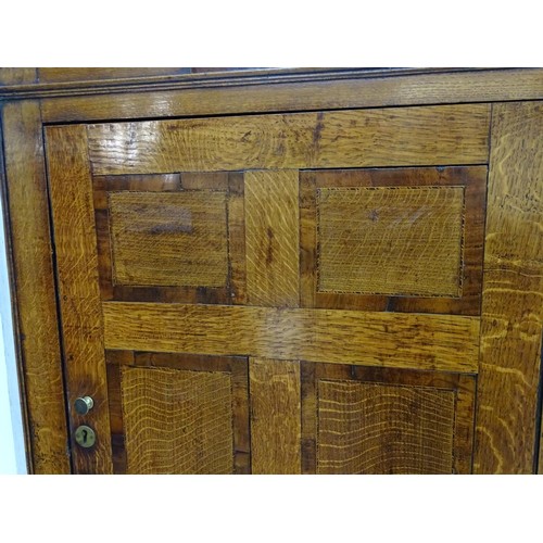 1718A - A mid / late 18thC oak double corner cupboard with a moulded cornice above a satinwood inlaid frieze... 