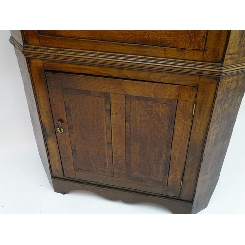 1718A - A mid / late 18thC oak double corner cupboard with a moulded cornice above a satinwood inlaid frieze... 