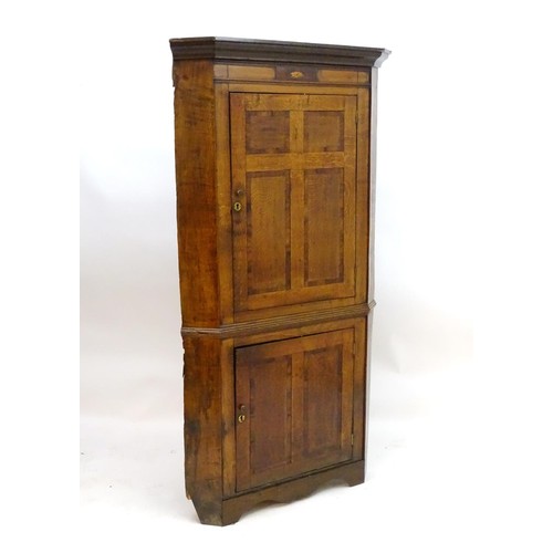 1718A - A mid / late 18thC oak double corner cupboard with a moulded cornice above a satinwood inlaid frieze... 