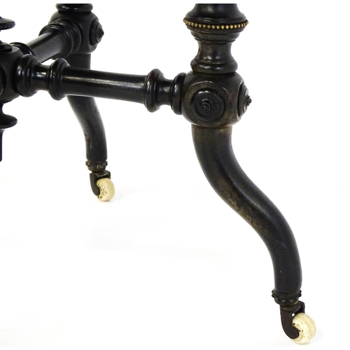 1869 - A Victorian ebonised occasional table with a circular brass studded top above four turned tapering l... 