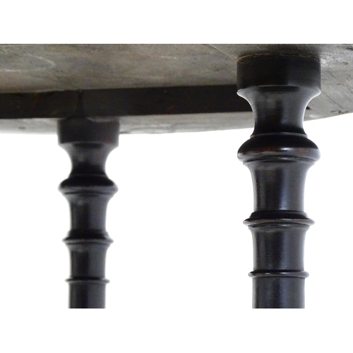 1869 - A Victorian ebonised occasional table with a circular brass studded top above four turned tapering l... 