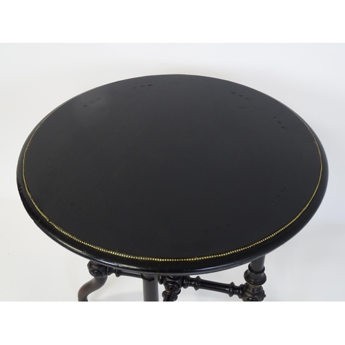 1869 - A Victorian ebonised occasional table with a circular brass studded top above four turned tapering l... 