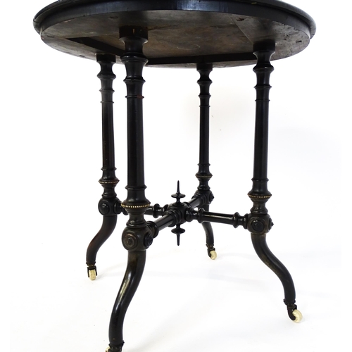 1869 - A Victorian ebonised occasional table with a circular brass studded top above four turned tapering l... 