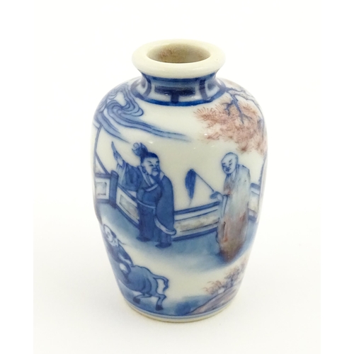 9 - A small Chinese blue and white vase depicting figures in a landscape. Approx. 2 3/4