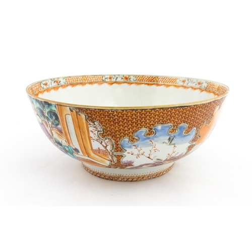 18 - A Chinese Export punch bowl decorated in the Mandarin palette with figures in a landscape with river... 