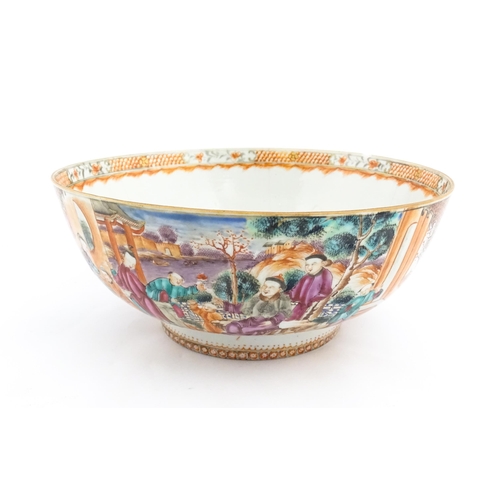 18 - A Chinese Export punch bowl decorated in the Mandarin palette with figures in a landscape with river... 