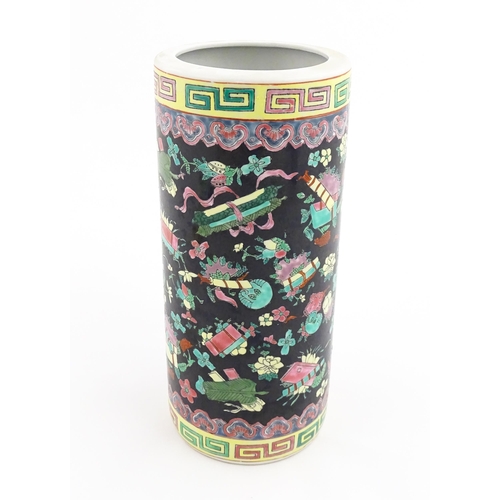 21 - A Chinese famille rose vase of cylindrical form decorated with auspicious symbols on a black ground.... 