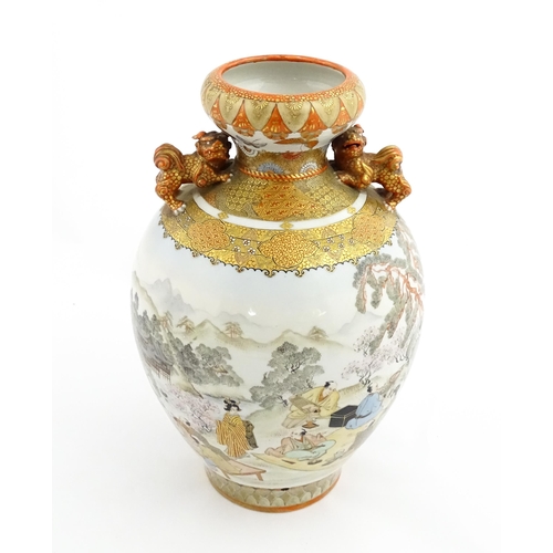 30 - A Japanese Kutani vase with twin foo dog handles decorated with figures in an extensive landscape. C... 