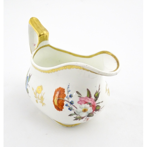 63 - An English cream jug with hand painted floral decoration and gilt highlights. Together with a pair o... 