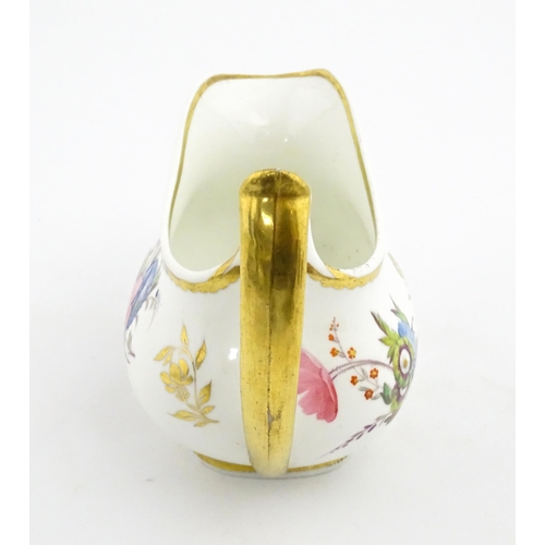 63 - An English cream jug with hand painted floral decoration and gilt highlights. Together with a pair o... 