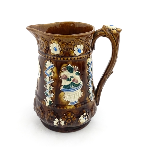 157 - A Victorian Measham bargeware jug with Forget Me Not motto, decorated with flowers, foliage and havi... 