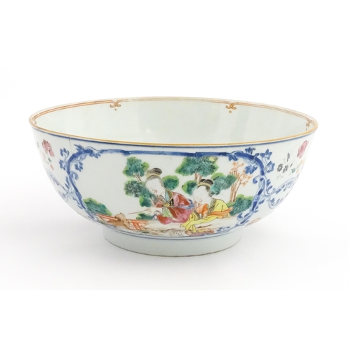 43 - A Chinese Export famille rose punch bowl decorated with two figures and a dog, birds, flowers and fo... 